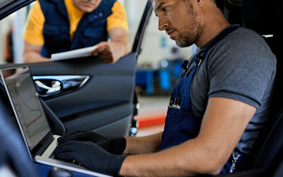 Technicians performing repairs on Land Rover inside vehicle | Royalty Auto Service